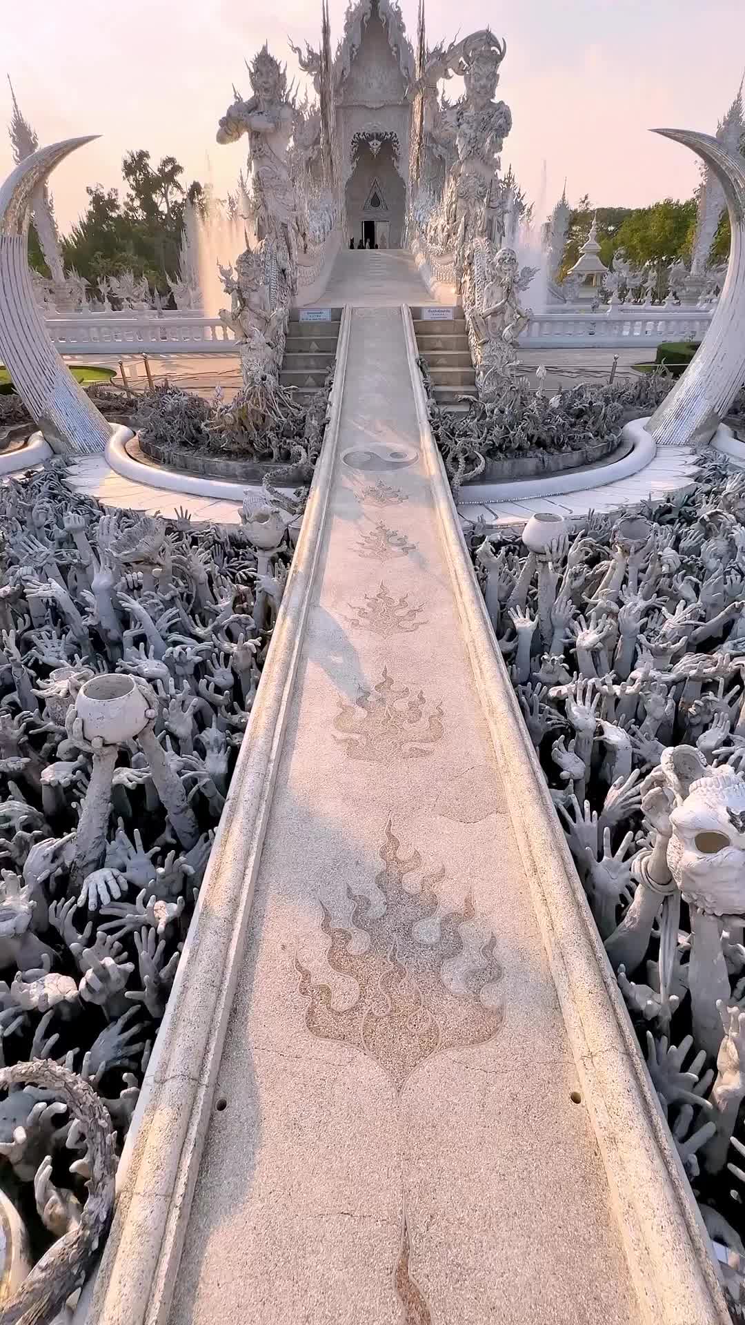 Walk up the Bridge of Rebirth, and have the guardians, Death and Rahu, decide your fate!

A POV of what it’s like to walk through Wat Rong Khun, the hands coming out of the moat are intimidating but beckon you to take a closer look 👀

This is a rare moment where there isn’t a line of people on the bridge, either be the first in line or come at closing, because you can’t go back down the bridge!  I heard it’s bad luck?  But also maybe they just don’t want people going back and forth, if so I may have a few years bad luck 😅

#watrongkhun #chiangrai #chiangraithailand #thailandtemple #thailandinsider #visitthailand
#adventureisoutthere #bestplacestogo #beautifuldestinations #bestvacations #gltlove #explorerbabes #girlswhotravel #womentravel #travelinspo #girlsthatwander #travelgirls #girlsborntotravel #travelandleisure #travelreels #vacationgoals #travelgoals #postcardplaces