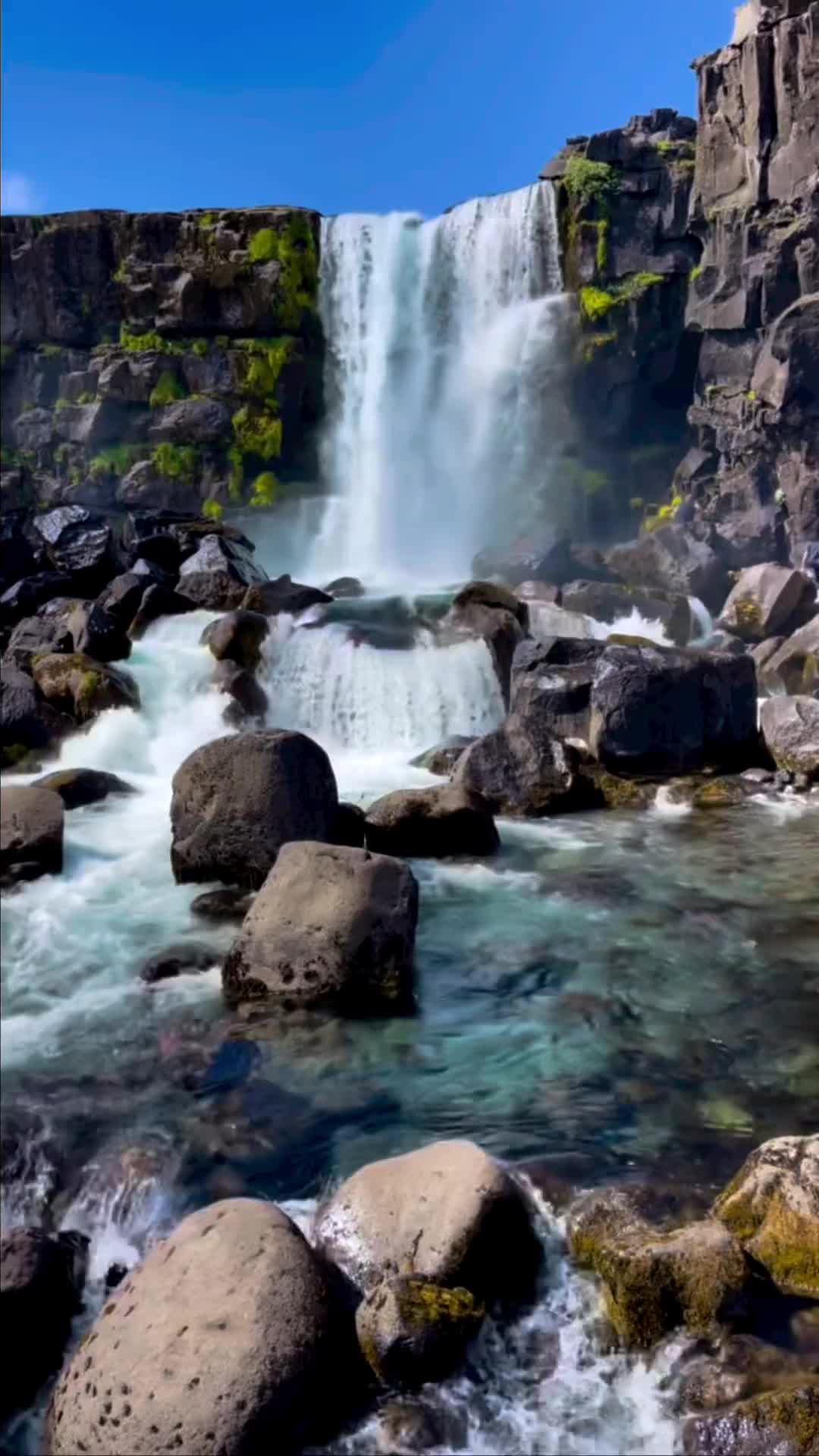 Did you know this waterfall in Iceland is technically man made?

You'll find this waterfall just inside Thingvellir National Park, but you won't see it on the drive up, despite being mere feet from the road. To get there, you'll take a quick walk down into a cliff-lined ravine and along the cliffs (it's less than ten minutes from the parking lot). This is the perfect place to not only see a stunning waterfall, but also get a close look at the massive rocks jutting up from the tension between the Eurasian and North American tectonic plates. This waterfall was also manmade, in way, considering the Oxarar River was physically moved in the 9th century to better provide water to the members of the parliament.
.
.
.
.
.
.
.
#oxararfoss #öxarárfoss #iceland #icelandtrip #icelandtravel #icelandroadtrip #icelandnature #icelandlove #icelandadventure #iceland🇮🇸 #icelandic #iceland2022 #icelandsecret #icelandscape #icelandexplored #visiticeland #icelandtour  #exploreiceland #discovericeland #igersiceland #waterfall #waterfallchasing #waterfalls #waterfalllovers #waterfallhike #waterfallhunting #waterfallporn #waterfallsofinstagram #waterfalling #waterfalladventures